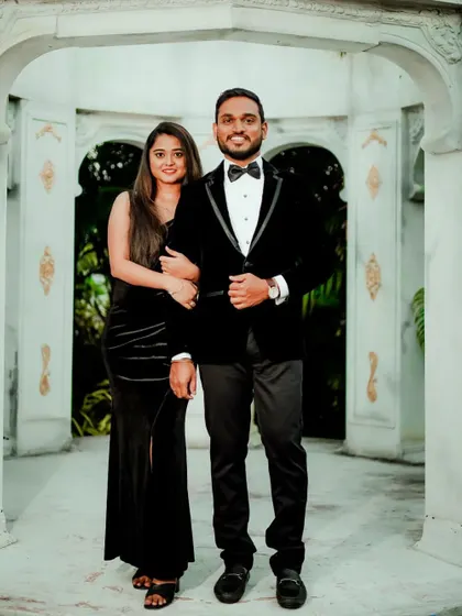 This full-length shot shows the elegant coordination of the black velvet gown and tuxedo, a timeless choice for any formal occasion.