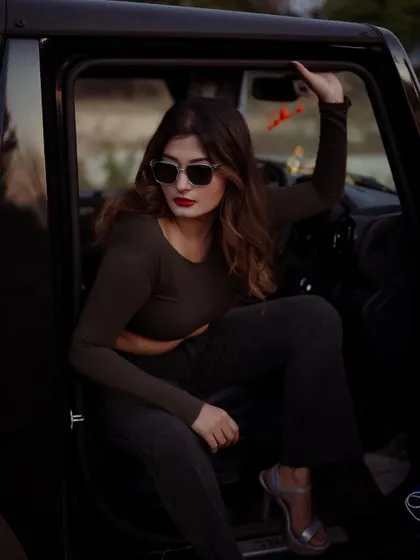 A moody portrait of a model in a car at dusk. The low light and her expression create a cinematic and intriguing image.
