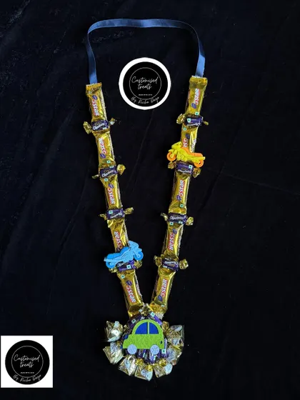 This fun chocolate garland is perfect for a little boy who loves cars. It features 5 Star chocolates and is decorated with colorful toy cars, making it a playful and delicious Holi gift.