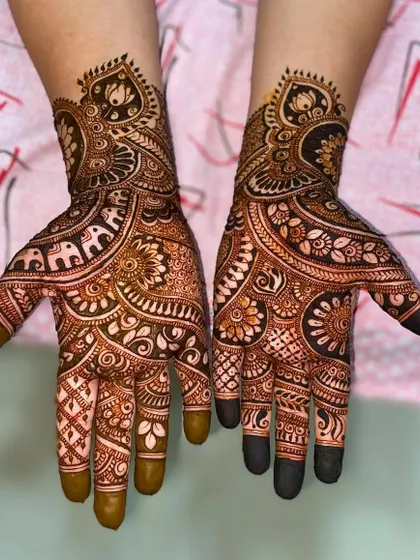 An elaborate design filled with traditional motifs, including elephants, lotuses, and intricate floral patterns, perfect for a bride or close family member.