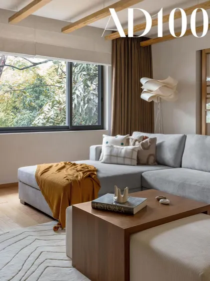 A cozy L-shaped sofa and a large window with a view of the trees. This space, featured in AD100, is all about comfortable, livable luxury.