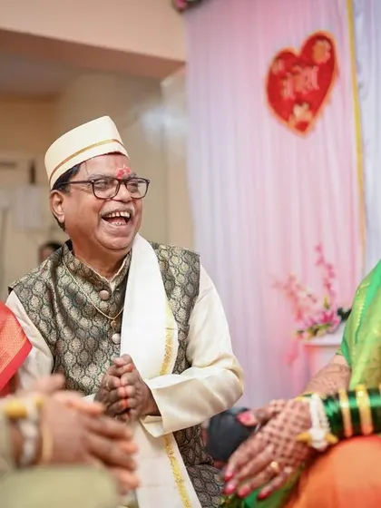 A priceless candid shot capturing the genuine laughter and joy of the bride's parents during the wedding rituals.