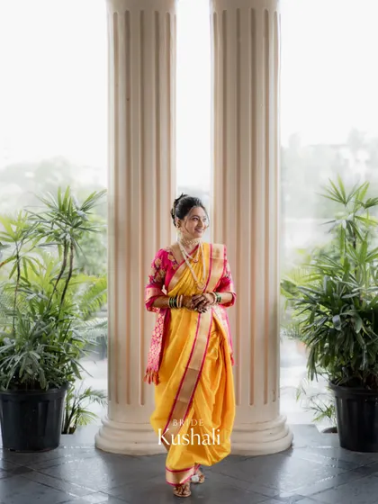 A stunning portrait of the bride standing between two pillars, perfectly framed and showcasing her entire wedding look.