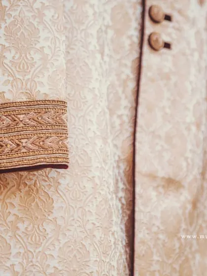 Highlighting the detailed embroidery on the cuff of the groom's sherwani. These small details are part of the larger story.