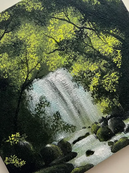 A detailed macro shot of the waterfall painting, focusing on the fine brushstrokes that create the illusion of moving water and light.