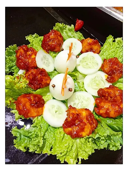 Even a simple salad can be fun. Here, I have arranged spicy chicken bites on a bed of lettuce with cucumber slices and a cute little garnish made from a boiled egg.