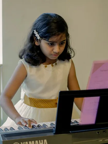 A young pianist concentrating on her sheet music during a performance. The dedication of our students is always so inspiring to witness.