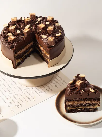 Our whole Snickers Cake, ready to be the star of your celebration. It's the perfect blend of familiar candy bar flavor and gourmet cake craftsmanship.