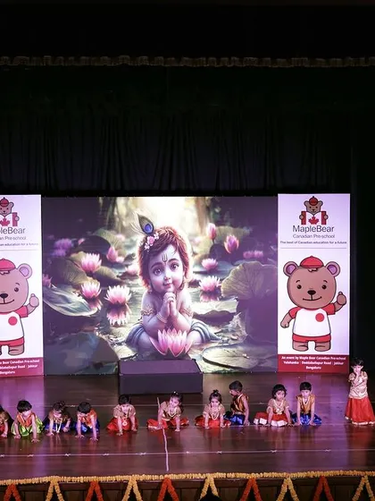 A wide shot of the stage showcasing the full setup for a performance. You can see the large LED screen, branded banners, and the young performers ready for their scene, demonstrating a complete production environment.