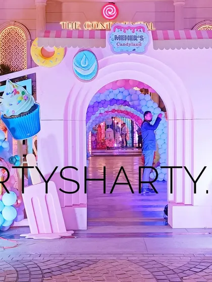 Welcome to Candyland! This whimsical entrance features giant props of cupcakes, ice cream, and donuts. The pastel color palette and arched entryway create a sweet and inviting atmosphere for a candy-themed celebration.