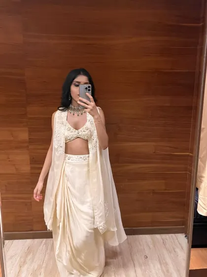 A happy client sharing a look at her custom-draped skirt and blouse set. This Indo-Western ensemble, with its elegant jacket and modern silhouette, shows how we can create the perfect party outfit that is both stylish and comfortable, even through remote consultations.