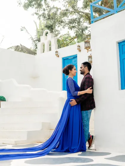 A full-length shot of the couple, with the bride's long blue train spread across the steps.