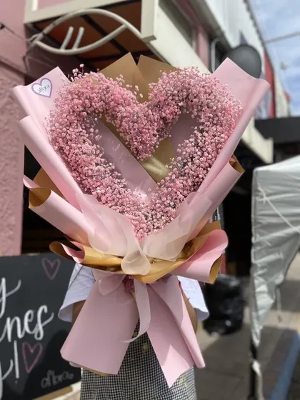 A creative twist on a classic bouquet. This arrangement uses pink baby's breath to create a heart shape, making it a beautiful and unique gift for someone you love.