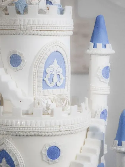 A close-up of the intricate details on the castle cake, from the textured walls to the tiny windows.