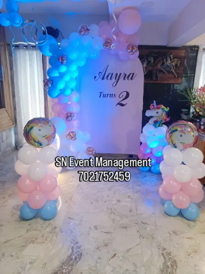 A pastel-colored butterfly and unicorn theme for Aayra's 2nd birthday. The simple arch backdrop is decorated with a soft balloon garland, creating a sweet and gentle look.