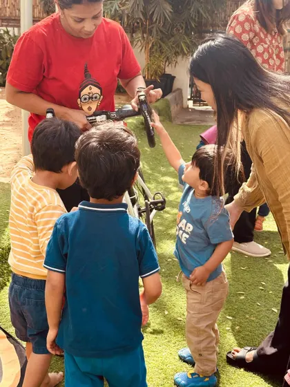 A child points to a part of the bicycle, full of questions. We encourage this curiosity and see every question as an opportunity for learning and discovery.