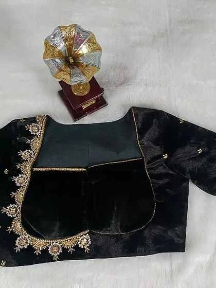 A luxurious black velvet blouse with a unique back design and delicate gold embroidery.