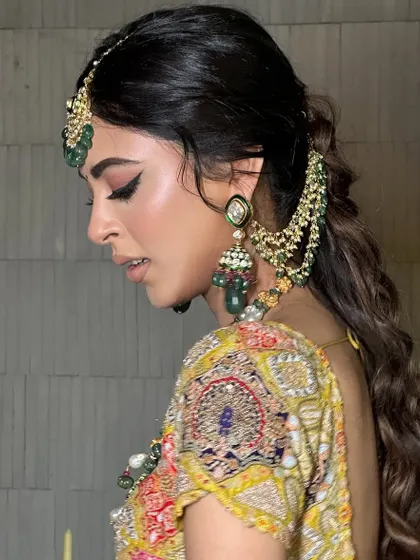 A side profile showcasing the winged liner and the intricate hairstyle. Every detail is carefully considered to create a cohesive royal look.