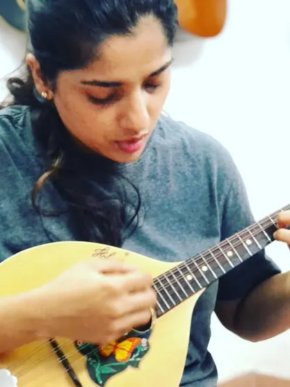 This student is focused on her picking technique for the mandolin. Its eight strings are tuned in pairs, which allows for techniques like the tremolo to create a sustained sound.
