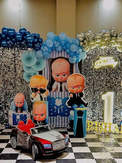Here is a full view of one of my popular Boss Baby themed decorations. The setup includes a wide shimmer backdrop, a complete set of character cutouts, themed balloon columns, and a checkered floor to match the theme's style.