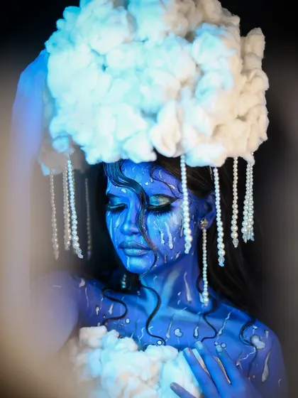 This shot highlights the cotton-cloud headpiece with hanging pearl "raindrops."