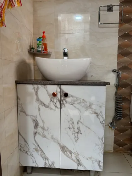 A simple and functional bathroom vanity unit. The marble-finish laminate on the doors is waterproof and easy to maintain.