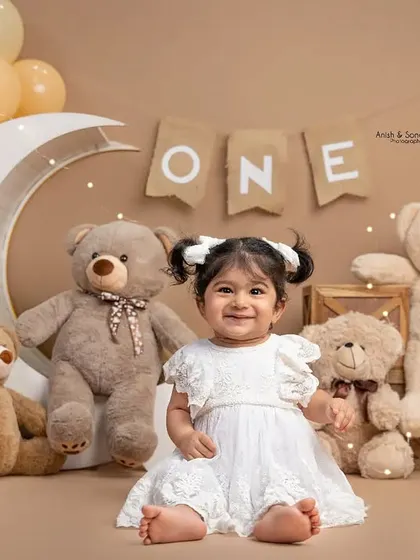 Look at that happy face! Before the smashing began, we captured this sweet portrait of the birthday girl in her beautiful white dress, surrounded by her teddy bear friends.