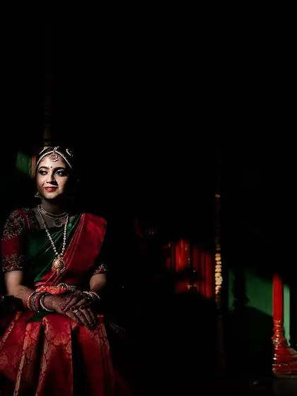 A bride seated in a traditional setting, with beautiful rays of light creating a dramatic and painterly effect. A perfect blend of light, shadow, and color.