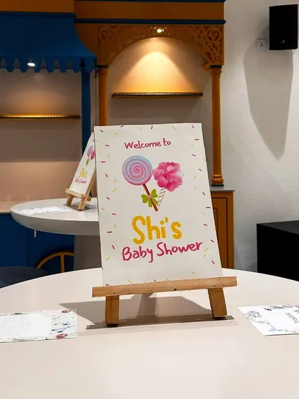 A mini welcome sign for the Candyland baby shower, placed on each table to carry the theme throughout the entire space.