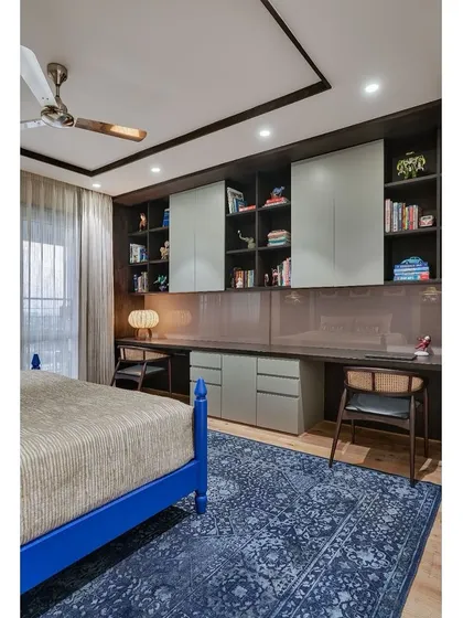 The son's bedroom includes a custom-designed study area with ample storage, ensuring the room is as functional for homework as it is for rest.