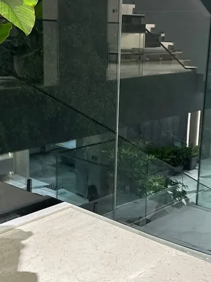 A view from the top of a modern staircase, showing how potted plants can be placed on different levels to integrate greenery throughout a multi-story home.