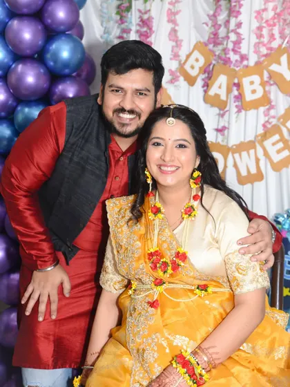 A joyful portrait of an expecting couple at their baby shower. Their bright smiles show the happiness of this special time.