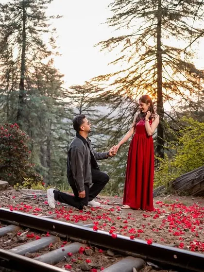 A heartfelt proposal on one knee, set beside the railway tracks with scattered petals. This is a moment of pure commitment captured in a uniquely romantic setting.