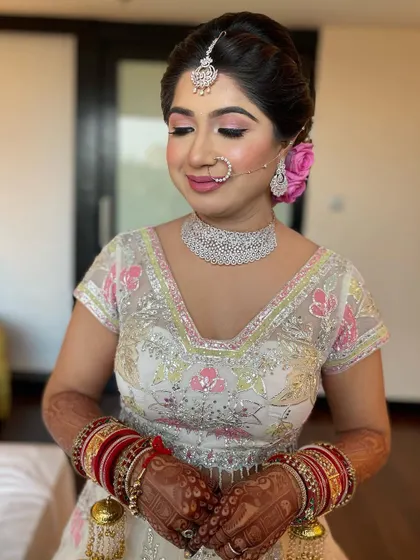 A close-up of the bride's pretty pink makeup and the rose in her hair.