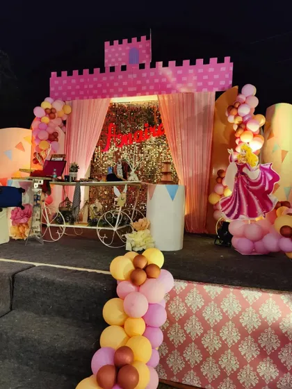 The main stage for the princess party, featuring a castle facade, a sequin backdrop, and a dessert cart.