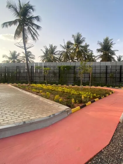 A view of the jogging track and newly planted beds at Vaishnavi Tech Square, set against a backdrop of coconut palms. This shows how we blend our designs with the existing local landscape.