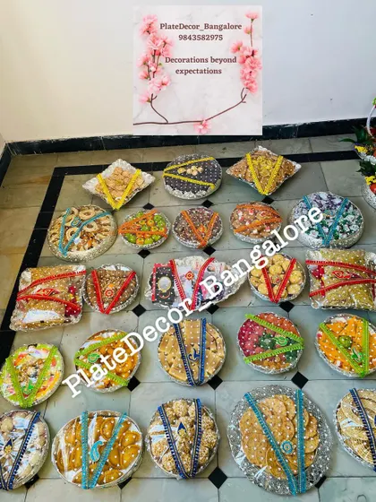 An overhead shot of a large order of seer plates filled with various sweets and savories, all packed and decorated for a function.