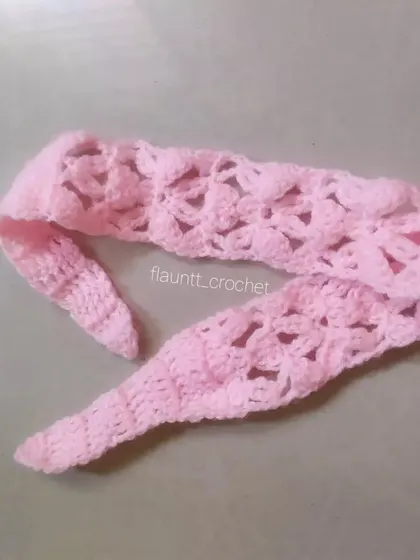 Another view of the pink crochet headband, showing the tapered ends that make it easy to tie.