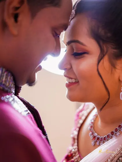 A close-up, intimate portrait of a couple sharing a quiet moment. The soft lighting highlights their happy expressions and connection.
