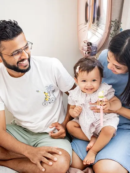 A casual at-home session celebrating a first birthday. The parents' expressions as they look at their daughter are so full of love and wonder. Home sessions are perfect for capturing your family in your most comfortable environment.