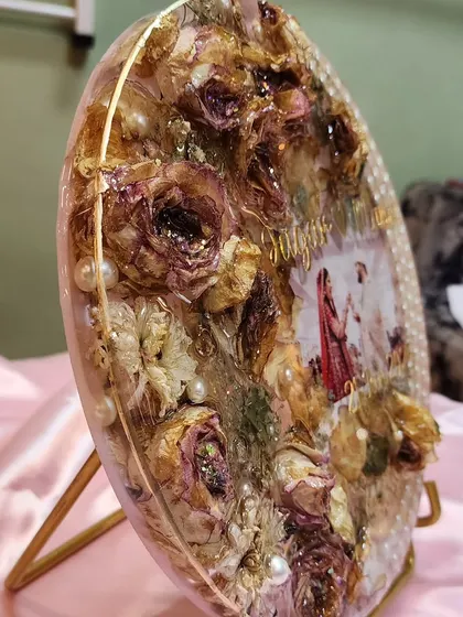 A side view of a 12-inch varmala preservation plaque I made for a couple. You can see the texture and depth created by layering the dried roses and pearls within the resin.