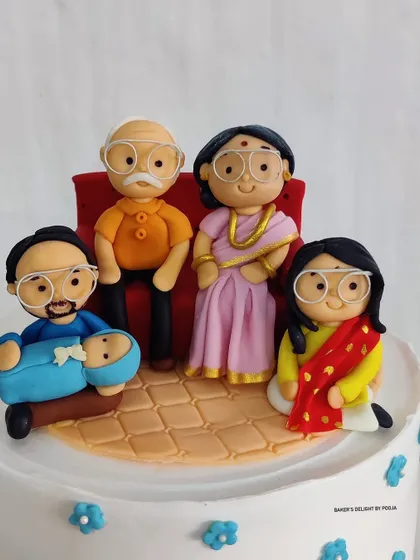 A close-up of the fondant family portrait. From the grandparents on the sofa to the new baby, each figurine was crafted with love to represent this beautiful family.