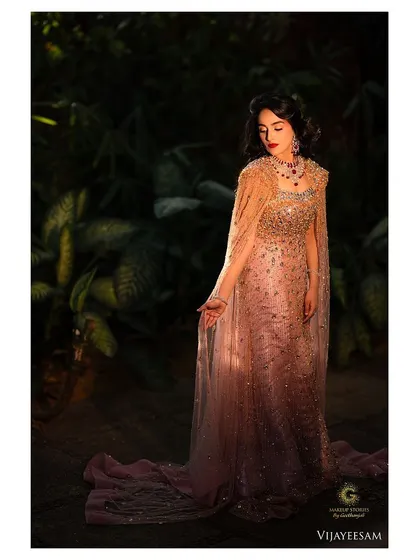 An ethereal full length shot in a garden setting. The makeup, with its classic red lip, adds a touch of timeless glamour to the romantic and dreamy atmosphere.