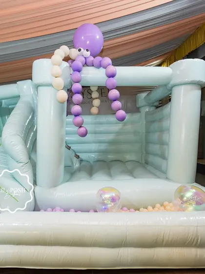 The full view of the incredible 3-in-1 bouncy castle, complete with a slide and ball pit, decorated with a balloon octopus.