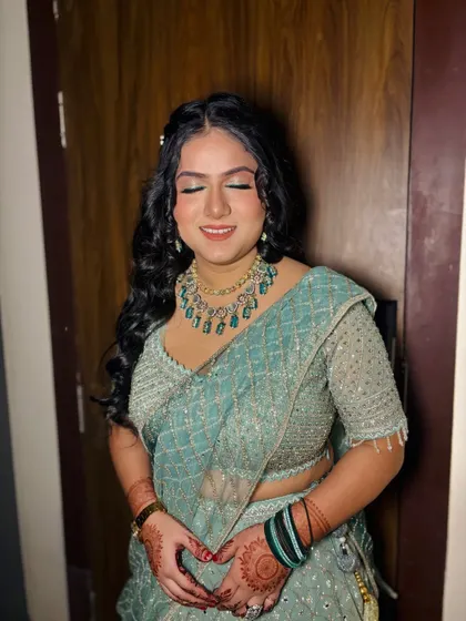 A client with soft curls and a beautiful green lehenga.