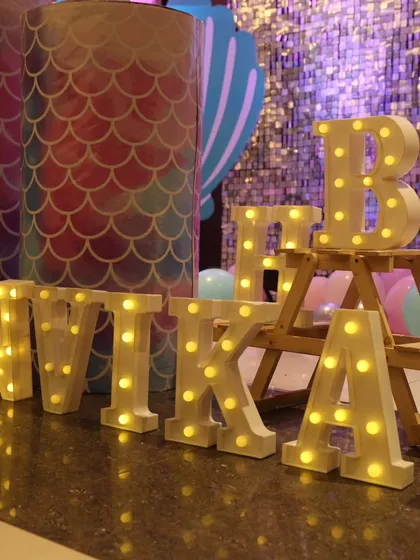 Personalized marquee letters add a special touch to any birthday setup. Here, the name 'ANVIKA' is lit up, adding warmth and a custom feel to the mermaid party decor.