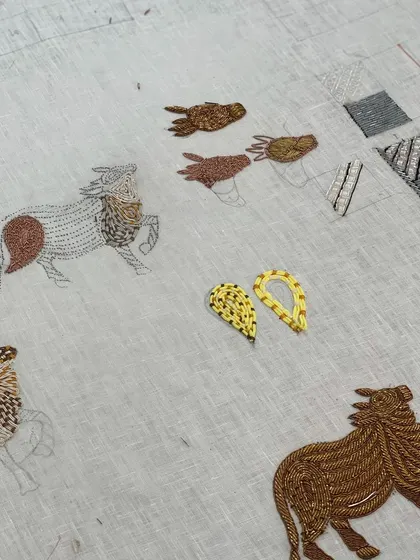 A work-in-progress shot of the "Gauri Series." You can see the initial sketches on the linen and the first sections of embroidery being filled in, bringing the sacred cows to life stitch by stitch.