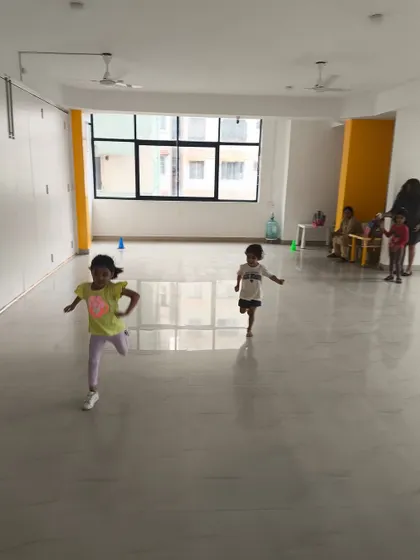 Two children enjoy a running game in the studio. Our indoor classes are designed to be just as active and high-energy as our outdoor sessions.