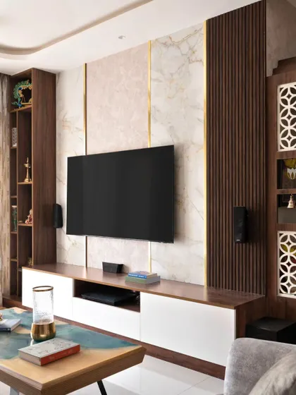 A closer look at the 'Muditā' media wall, showing the interplay of marble-finish panels, brass inlays, and dark wood fluting. The design is layered and luxurious.