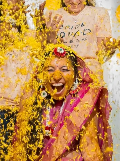 A moment of pure exhilaration as the bride is showered with turmeric and petals by her bride squad.